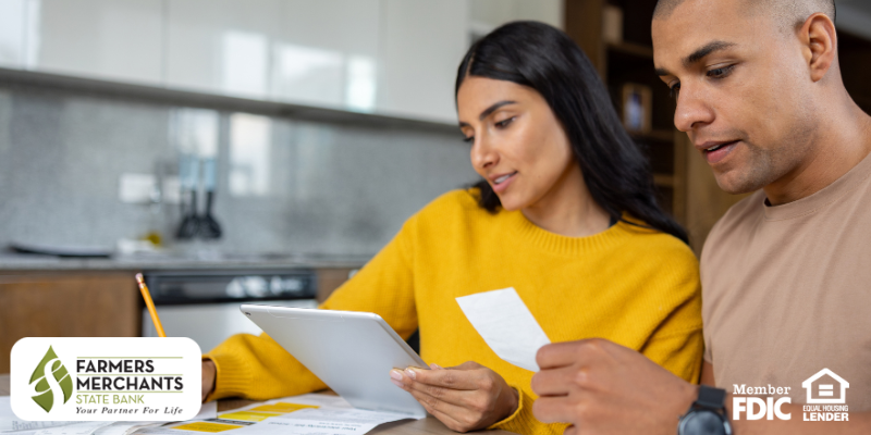 Young couple organizing their receipts and finances at the kitchen table