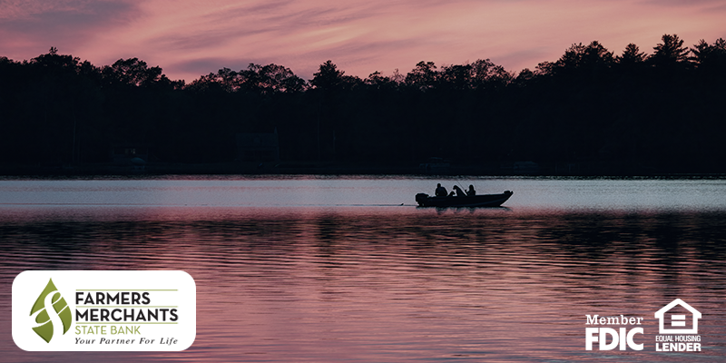 People on a small boat on a lake during sunset