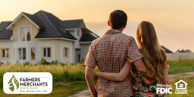 Man and woman with arms around each other looking at house in the distance