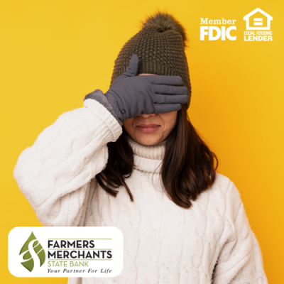 Woman in sweater and winter hat with gloves on and her hand over her eyes