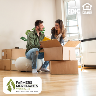 Couple smiling at each other in front of a stack of boxes as they are packing up their house