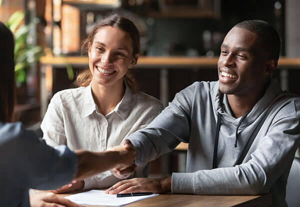 couple shaking hands with a banker