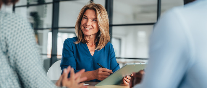 Businesswoman in conversation with a couple over mortgage loans in her office